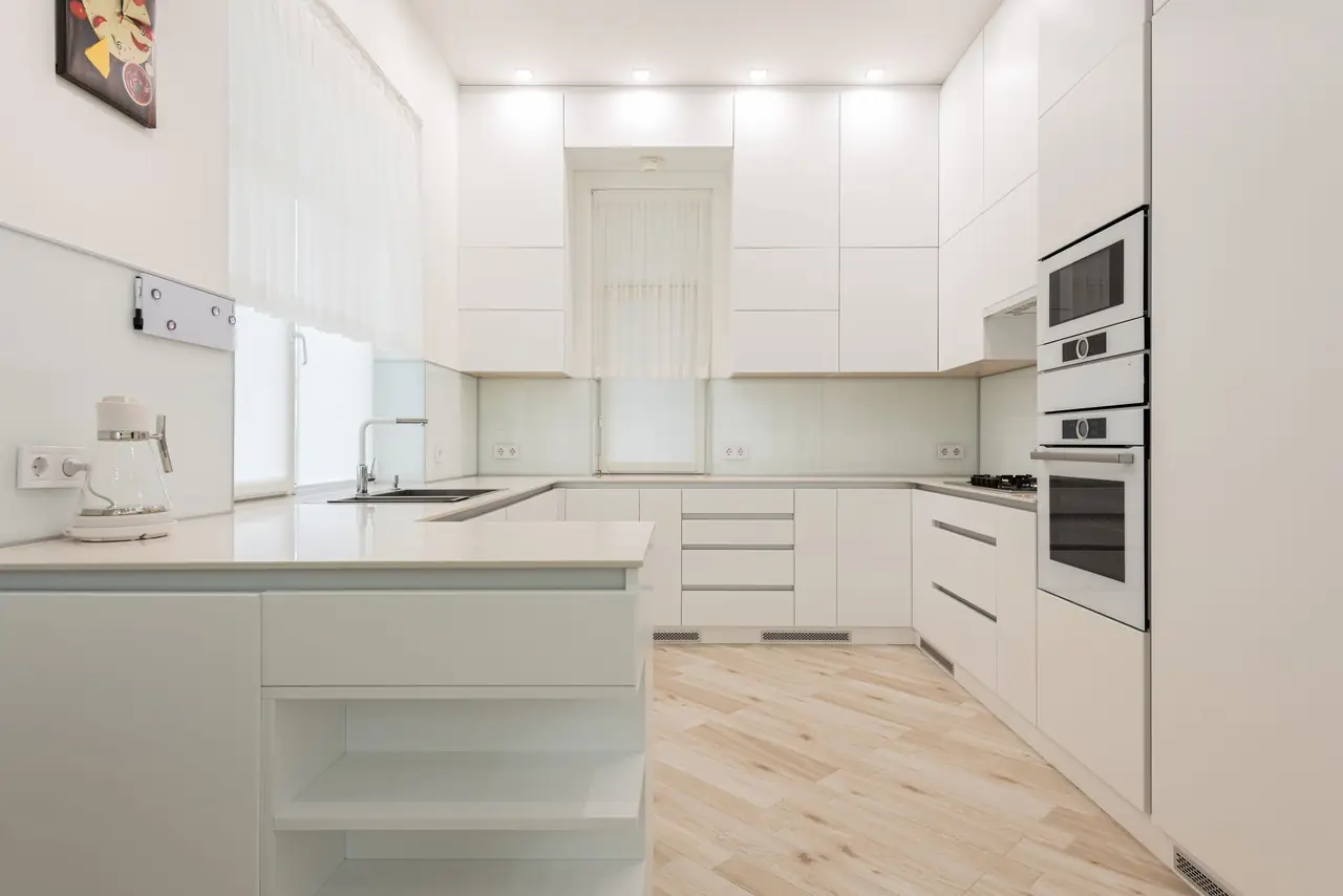 Cuisine blanche impeccable et lumineuse d'un appartement