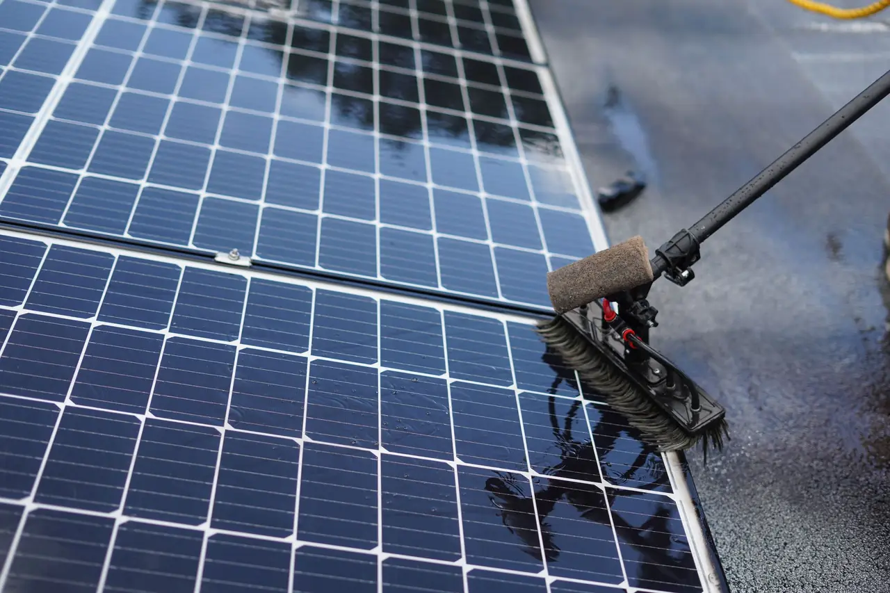 Brosse professionnelle nettoyant des panneaux solaires sur un toit